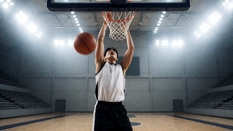 篮球比赛现场球员上篮瞬间，场馆灯光聚焦球场